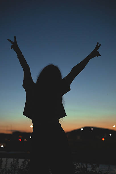 istock Girl with arms outstretched against the sky 2212185621
