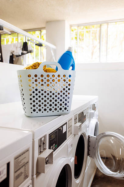 istock Bag with laundry and detergent on washer at laundromat 2212186754