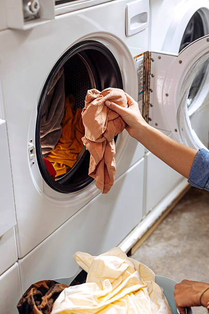 istock Hand putting used clothes into washer 2212187212