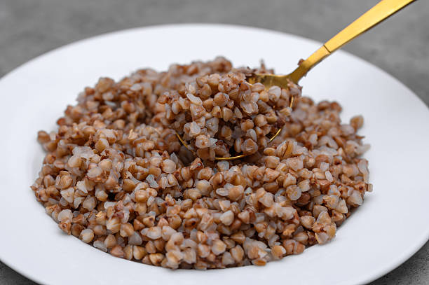 A portion of roasted buckwheat groats cooked until fluffy on a white plate,