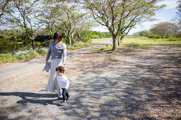Grandmother and her grandson walking under cherry trees
