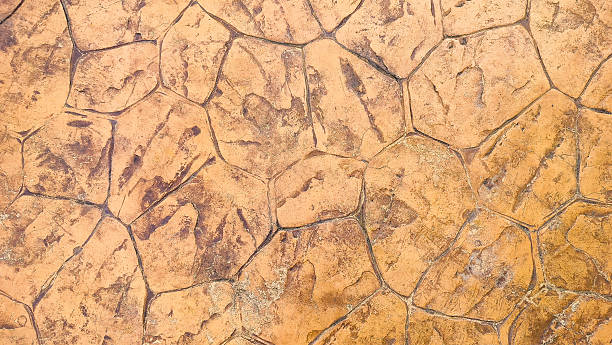 istock The background of brown cement tiles is scratched. Textured solid stone wall for backgrounds and wallpapers. Abstract texture and background fragments of brown ceramic tiles on cement wall. 2212189716