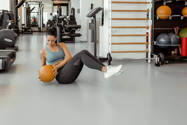 istock Female Athlete Performing Sit-Ups on Stability Ball at Gym 2212192107