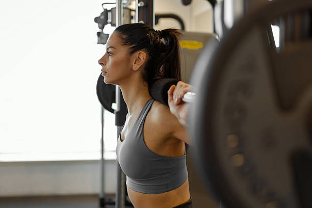 istock Woman Doing Barbell Squats in Modern Gym - Strength Training Workout 2212192169
