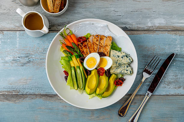 Healthy salad bowl with grilled chicken, avocado, egg, and blue cheese