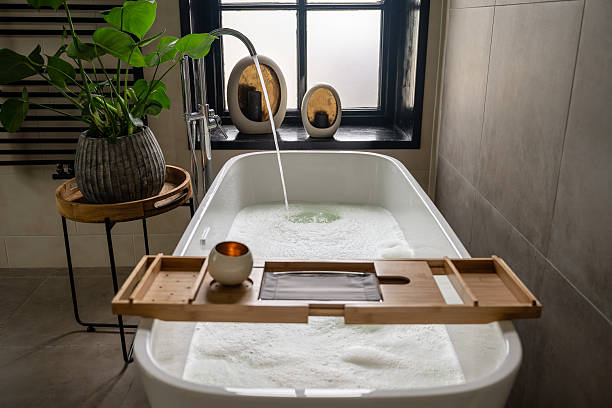istock Interior of bathroom with bathtub, dressing table, shelving and large window 2212196415