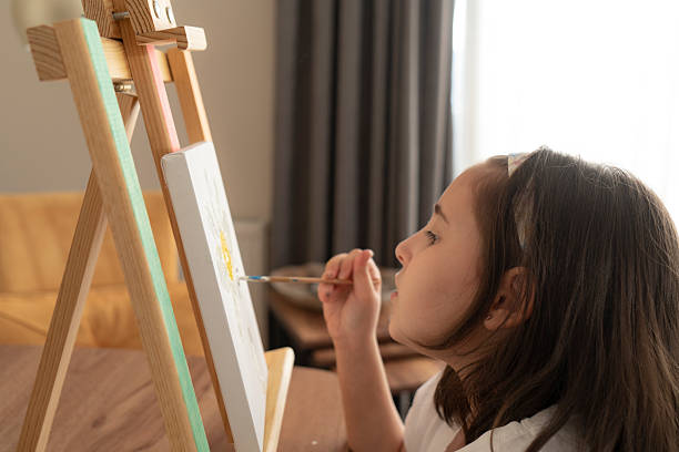 Little girl painting on a canvas