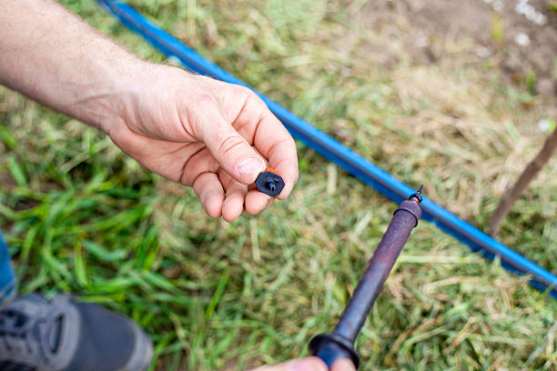 istock A man installs a drip irrigation system in a garden by melting a HDPE pipe with a hole punch to install adjustable water drippers 2212201042