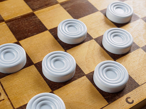 istock Checkers game setup on a checkered board. Strategy, game pieces, black and red, ready to play, board game. 2212202929