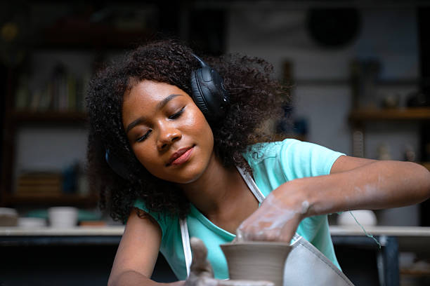 African woman make earth ware at workshop. Small business, hobbies.