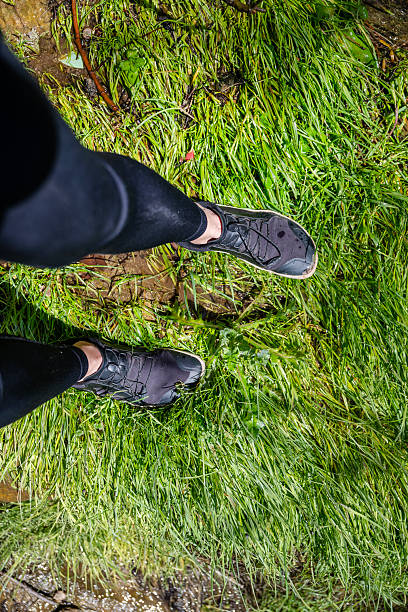 istock Legs with barefoot hiking shoes on green grass 2212203670