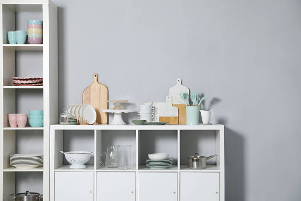 istock Shelving unit and storage cabinet with kitchenware near grey wall indoors 2212205678