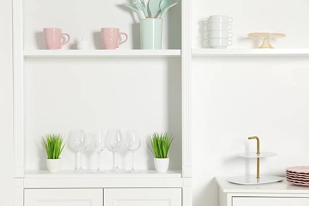 istock Shelving unit with different kitchenware near white wall indoors 2212205691