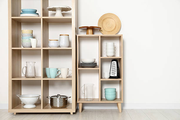 istock Wooden shelving units with kitchenware near white wall indoors 2212205692