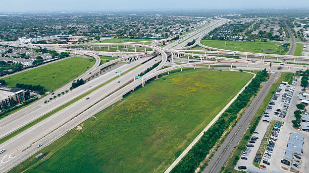 istock Upscale auto dealer with cover parking spots near multilevel stack interchange road junction, highway bridge Dallas North Tollway, President George Bush Turnpike, Plano suburbs Dallas metroplex 2212210254
