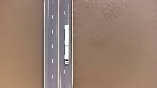 Semi trailer truck crossing a bridge over a river