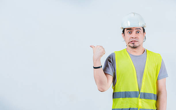 istock Surprised builder pointing at an isolated advertising space. Amazed construction worker pointing at an isolated blank space 2212211121