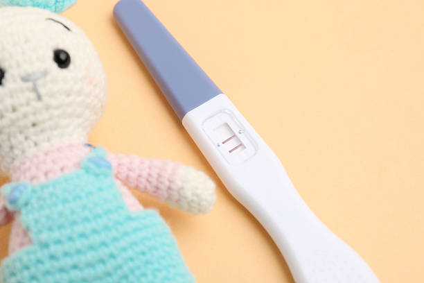 Close up unused pregnancy test on the orange background with copy space. Planning of pregnancy