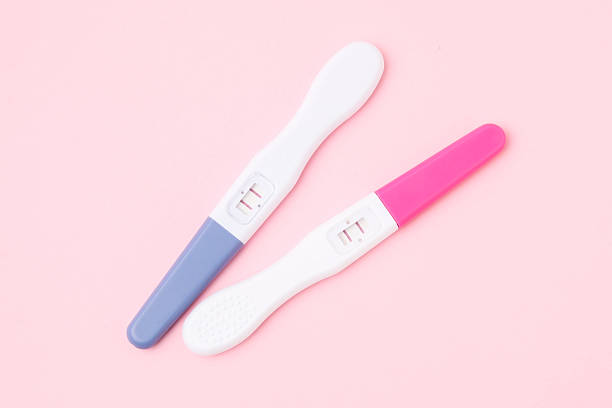 istock Pregnancy tests on pink background, top view 2212212703