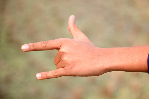 istock A man pointing two fingers of his hand forward and green background 2212214961