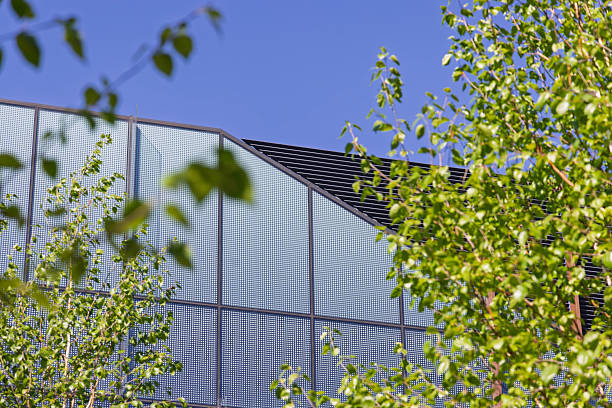 istock Modern architecture contrasts with lush greenery in a sunlit urban setting, showcasing sustainable design principles in a public space 2212215280