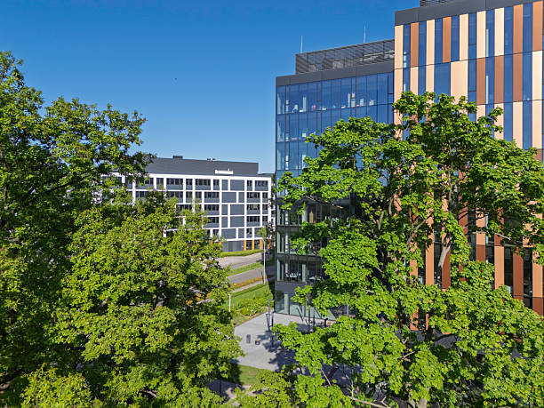 istock Modern office buildings surrounded by lush greenery in a vibrant urban landscape during a clear sunny day 2212215675