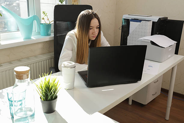 istock Young Professional Woman Working Intensely on Laptop in Bright Modern Office 2212221477