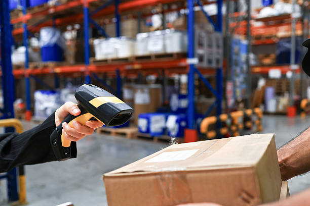istock employee scanning barcodes on packages, checking cardboard boxes in warehouse with tablet. Person doing merchandise inventory or logistics, preparing distribution. Handheld shot. 2212228519