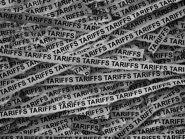 istock Strips of newspaper with the words Tariffs typed on them 2212234254