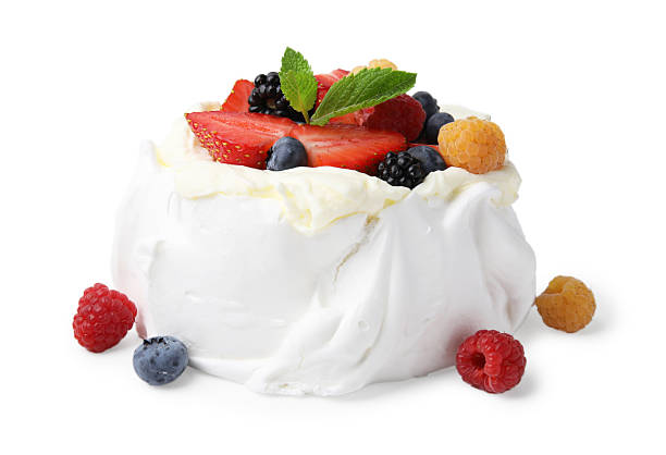 istock Pavlova cake (meringue dessert) with whipped cream, fresh berries and mint isolated on white 2212237474
