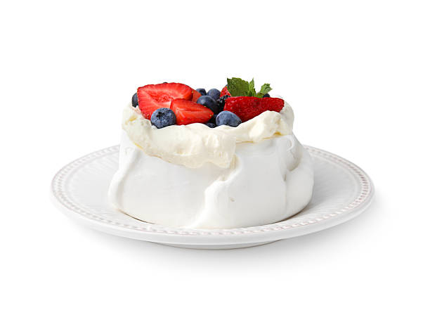istock Pavlova cake (meringue dessert) with whipped cream, fresh berries and mint isolated on white 2212237475