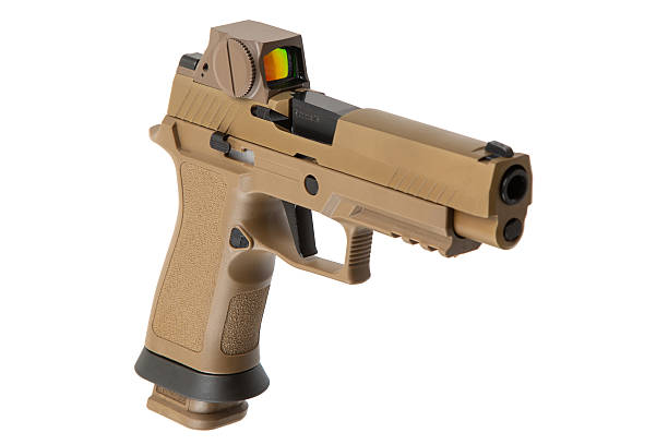 istock A tan-colored semi-automatic pistol with a textured grip and a mounted red dot sight, isolated on a white background. 2212240251