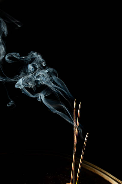 istock Three burning incense sticks with smoke on a black background. 2212242977