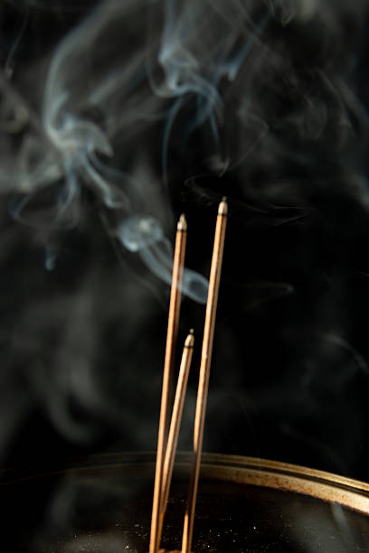istock Three burning incense sticks with smoke on a black background. 2212242987