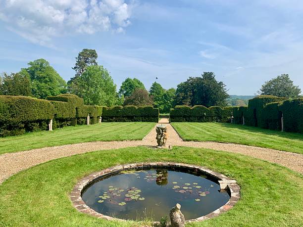 istock Pond and formal garden with gravel path and Yew hedging 2212249853