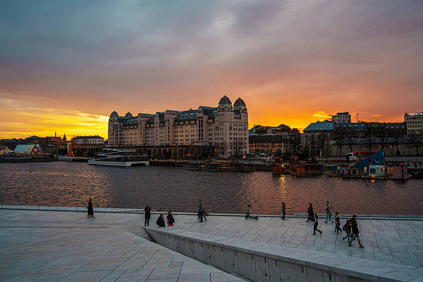 Oslo, Norway - Apr 13, 2024: A landscape of Oslo Opera House with people walking and relax around the area. The scene is set during twilight.