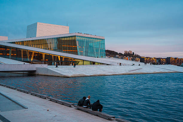 Oslo, Norway - Apr 13, 2024: A landscape of Oslo Opera House with people walking and relax around the area. The scene is set during twilight.