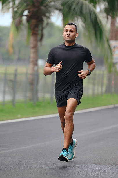 istock Athletic Man Running Outdoors on a Palm-Lined Track 2212251048