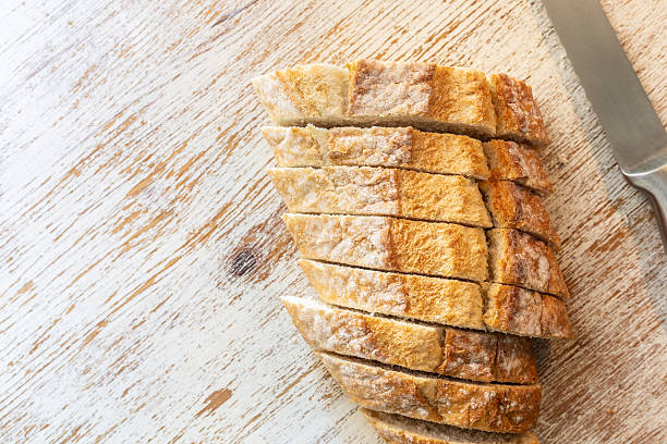 Sliced bread loaf on rustic wooden cutting board with knife