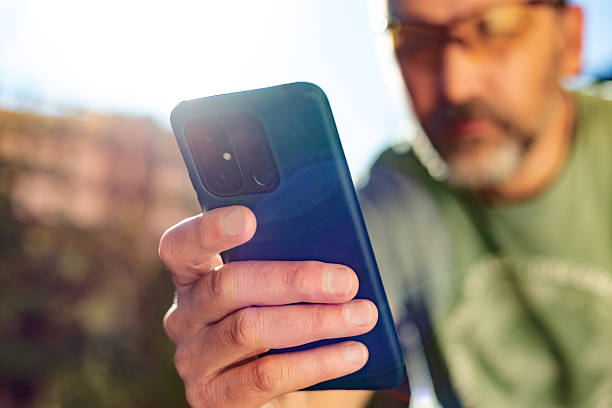 istock Mature adult man using smartphone outdoors in nature 2212252692