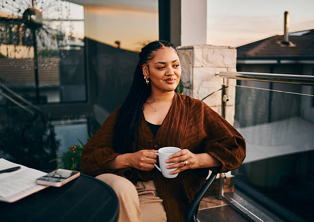 Confident Woman Relaxing with Coffee on Balcony