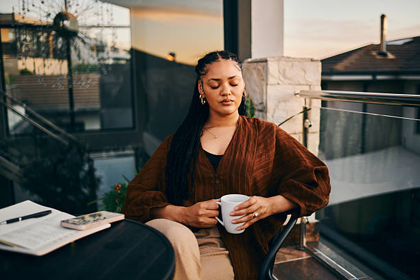 istock Serene Woman Relaxing with Coffee at Sunset 2212253517