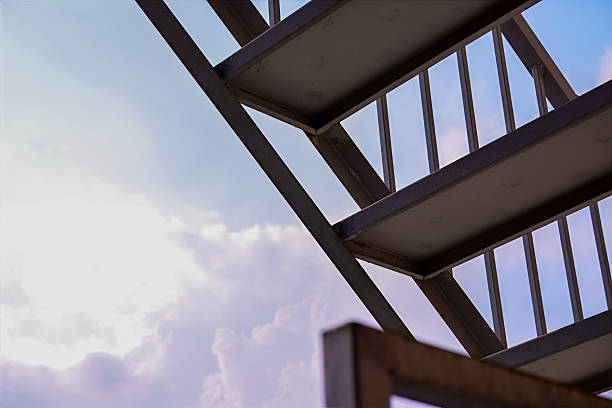 istock Metal Staircase Against Evening Sky with Fluffy Clouds 2212257590