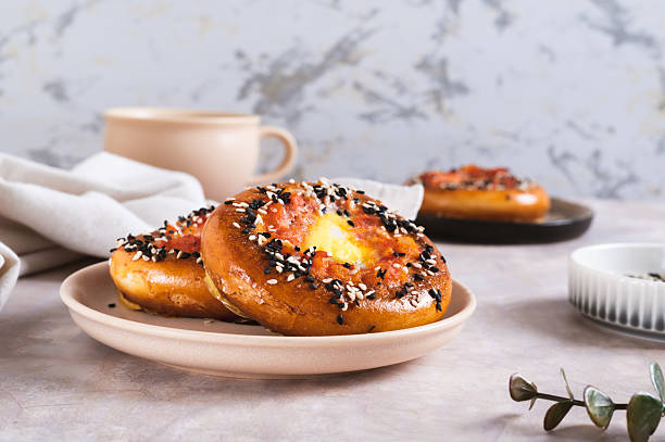 Baked bagels with tomato and quail egg on a plate on the table