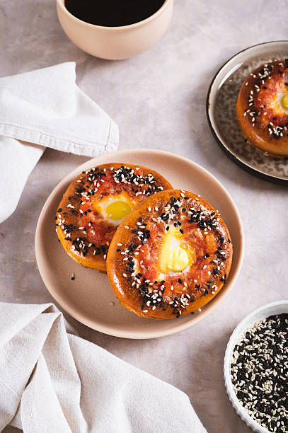 istock Egg with tomato and sesame seeds baked in bagels on a plate on the table vertical view 2212259621
