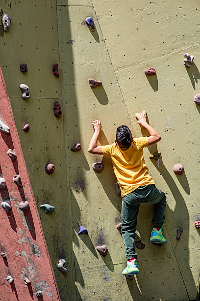 Boy climbing the climbing track - vertical shot