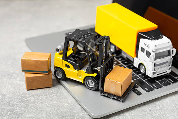 istock Yellow forklift on bright textured background. Logistics concept. Logistics and supply chain management for online shopping concept. Delivery of goods or products to the store worldwide. Cardboard box 2212263956