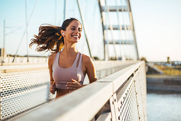 istock Smiling Woman Jogging on a Bridge During a Beautiful Day 2212265042