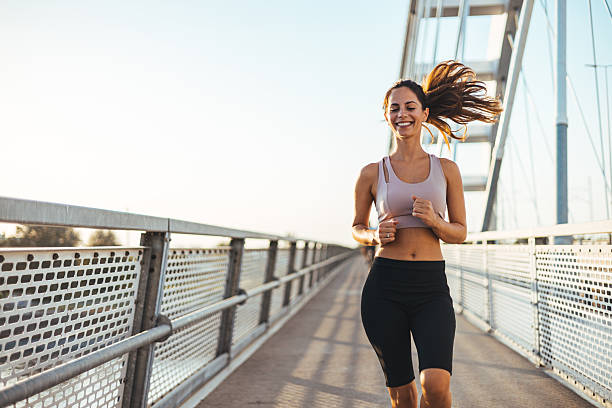 istock Smiling Woman Jogging on Bridge During Early Morning Run 2212265063