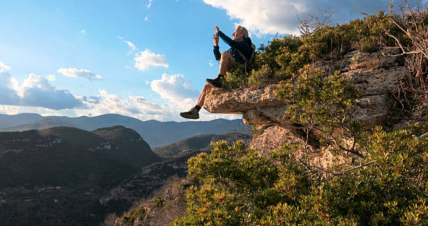 istock Hiker uses mobile phone on edge of mountain, Liguria 2212265524